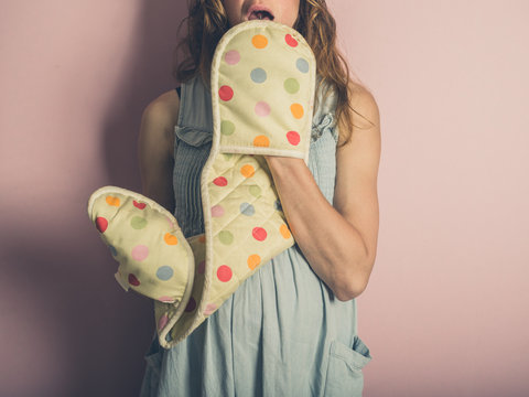 Young woman with oven gloves