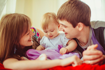 Happy parents admire their little girl playing with her violet d