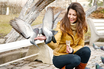 beautiful girl feeding pigeons in the park