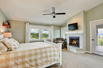 Master bedroom interior with fireplace and light olive walls.
