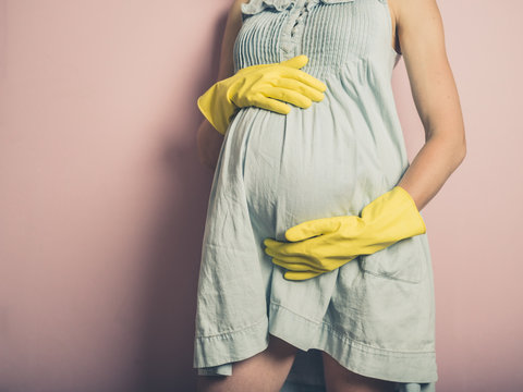 Pregnant woman wearing rubber gloves