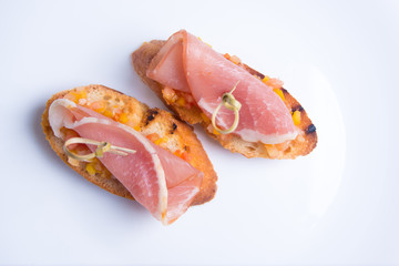 Bruschetta crostini with Parma ham, chopped tomatoes and peppers on a skewer. Italian cuisine