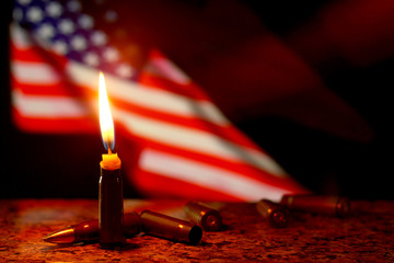Candles flag tragedy in USA weapons dark background.