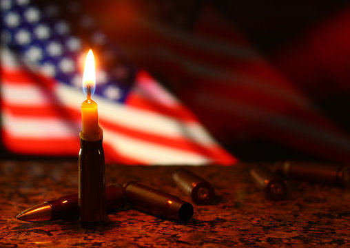 Candles flag tragedy in USA weapons dark background.