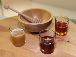 Different Type of Honey inside Glass and Wooden Honey Dipper and