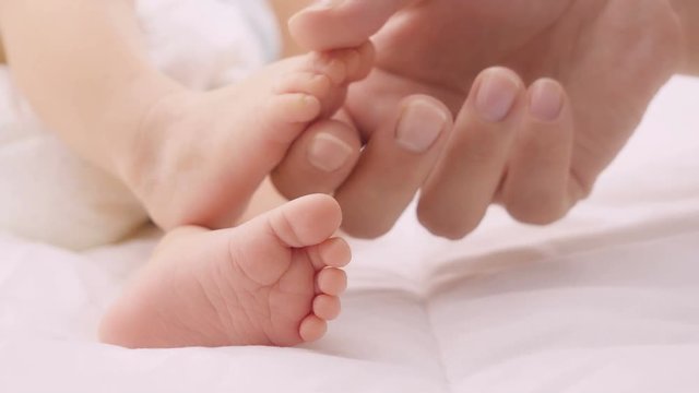 Baby feet in mother hands. Close up of little baby feet in hands of mother.