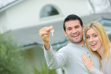 Couple holding keys to their new house
