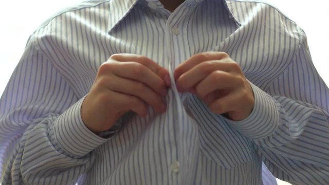 teen buttoning on the shirt
