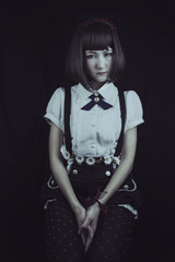 Retrato de estudio de una chica japonesa con ropa formal en una atmósfera de oscuridad 
