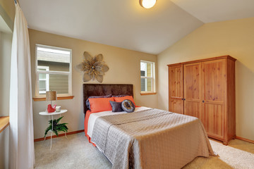 Upstairs bedroom with vaulted ceiling and beige walls