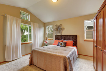 Upstairs bedroom with vaulted ceiling and beige walls