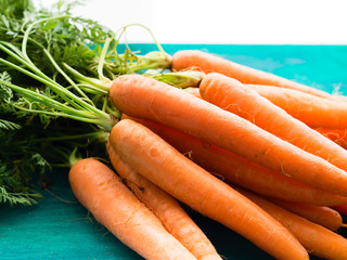 Bunch of carrots on green wooden background