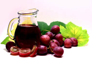 Red rose grapes bunch, glass jug bottle with red house wine or natural organic juice, and autumn green grape leaves isolated on white background.