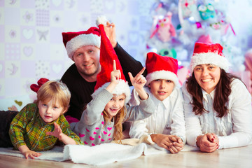 happy and beautiful family sitting together in red hats