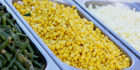 Fresh vegetables bar salad from yellow maize corn beans on a fast food sale plate, selective focus, close-up