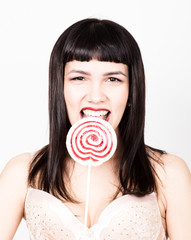 Portrait of happy beautiful young woman licking sweet candy and expressing different emotions