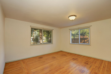 Empty room with hardwood floor and two windows