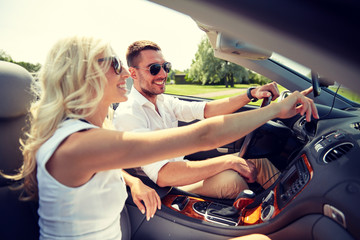 happy couple using gps navigator in cabriolet car