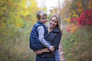 Fototapeta premium Mother with son in forest in autumn