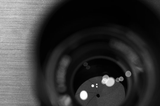 Fototapeta closeup macro of camera lense with reflections low key black and white image with aperture blades
