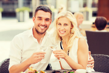 happy couple clinking glasses at restaurant lounge