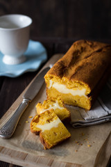 Homemade pumpkin bread with cream cheese filling on dark rustic background