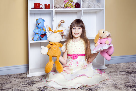 Happy little girl play with toys in her room.