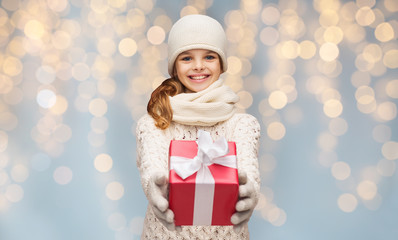 smiling girl in winter clothes with christmas gift