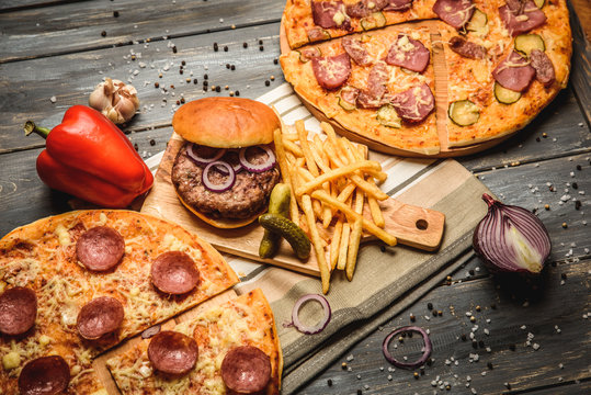 pizza and hamburger on wooden background