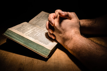 Bibel mit Händen beim Beten - Powered by Adobe
