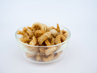 Crispy deep fried pork skin or pork rind in bowl isolated on white background