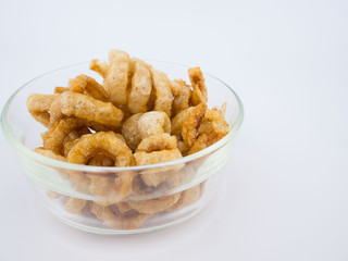 Crispy deep fried pork skin or pork rind in bowl isolated on white background