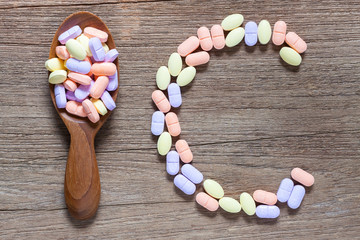 Vitamin C pills on a wooden table, supplemental diet, healthcare and wellness concept pills on a wooden table, supplemental diet, healthcare and wellness concept