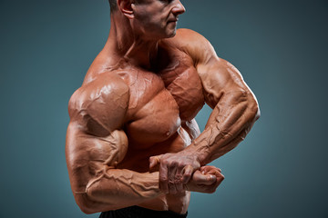 Fototapeta na wymiar The torso of attractive male body builder on gray background.