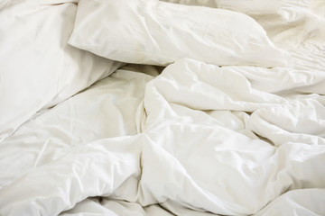 white pillow on bed and with wrinkle messy blanket in bedroom, f