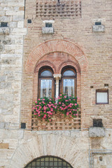 Fototapeta na wymiar A gothic window in a medieval building of San Gimignano, Tuscany, Italy