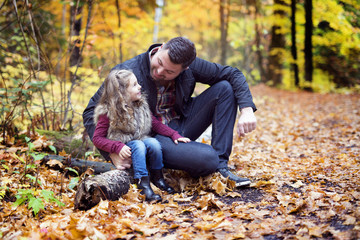 Naklejka na ściany i meble Little adorable girl with happy father in autumn park outdoors