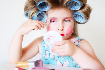 Adorable funny little girl making makeup with mother cosmetics
