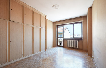 Empty old room with wooden floor and beige tapestry