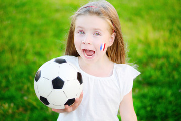 Adorable little girl supporting her national football team during soccer championship