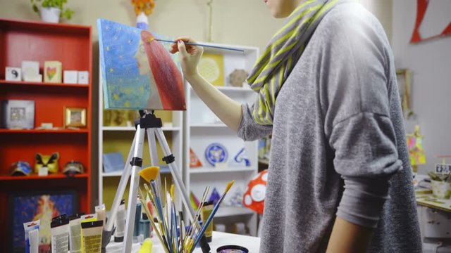 Woman painting on canvas in artistic room 4K
