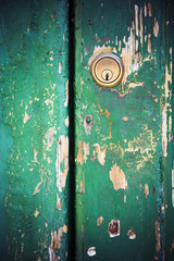 Keyhole lock on peeling painted green door