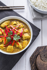 Chicken curry, with onions and chilli on the white table, vertical view, from above