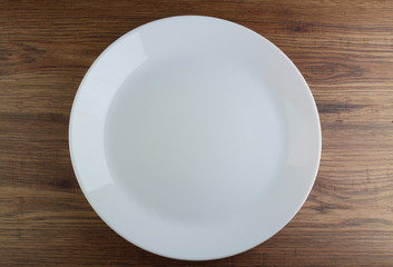 Wooden table in an empty white plate