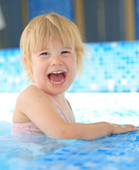 Fototapeta na wymiar Happy young girl in swimming pool
