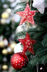 Craft red Christmas tree decorations and Happy New Years decoration hang on green spruce branch