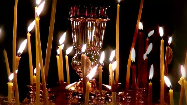 Cinemagraph the wax candles of the Church. Religious prayers and a plea for help. Inspiring the light of a candle in an elegant candlestick. Fire and the current wax in the night.
