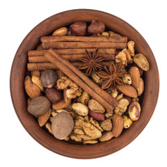 Mixture of nuts in a brown plate. Isolated on white background.