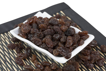 raisins in saucer isolated on white background