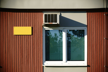 Baracke mit Lüfter / Eine Holzbaracke mit Bretterwänden ist mit einem Fenster und Lüfter ausgestattet.
